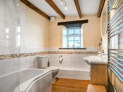 a bathroom with a tub and a toilet and a sink at Wharrastone - Uk50661 in Bude