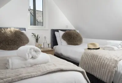 a room with two beds with towels on them at Tiddlywink in Newquay