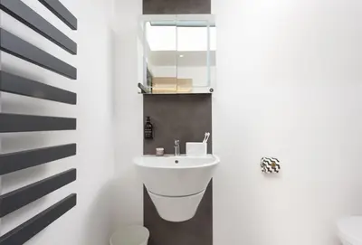 a white bathroom with a sink and a mirror at Tiddlywink in Newquay