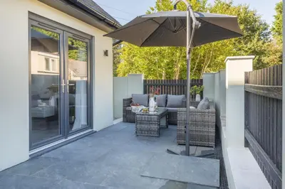 a patio with a table and an umbrella at Tiddlywink in Newquay