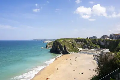 a beach with people on the sand and the ocean at Tiddlywink in Newquay