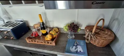 a counter with food and bottles of wine and a basket of fruit at Blue Lagoon Holiday ,Bude 79 in Cubert