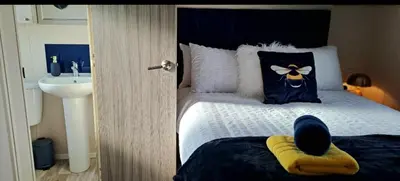 a bedroom with a bed with a sink and a bedskirtspectspectspectspects at Blue Lagoon Holiday ,Bude 79 in Cubert