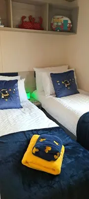 a bedroom with two beds with a blanket on them at Blue Lagoon Holiday ,Bude 79 in Cubert