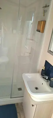 a white bathroom with a shower and a sink at Blue Lagoon Holiday ,Bude 79 in Cubert