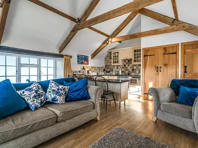 a living room with a couch and a kitchen at Raddons - Uk50657 in Bude