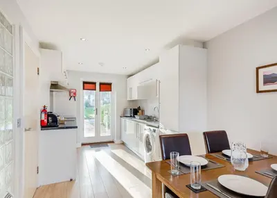 a kitchen and dining room with a table and chairs at Bay Retreat Villas in St Merryn