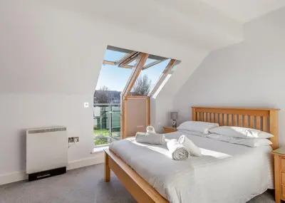 a bedroom with a large bed and a window at Bay Retreat Villas in St Merryn