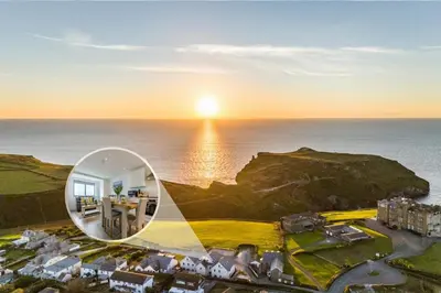 an image of a house with the sun setting over the ocean at 2 Bed in Tintagel oc-p33627 in Tintagel