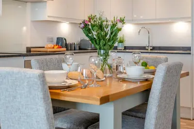 a kitchen table with a vase of flowers on it at 2 Bed in Tintagel oc-p33627 in Tintagel