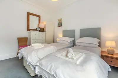 a bedroom with two beds with white sheets and a mirror at 4 Bed in St. Ives oc-t33609 in St Ives