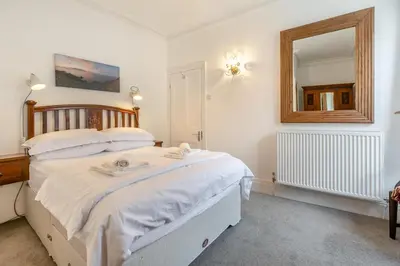 a bedroom with a large bed and a mirror at 4 Bed in St. Ives oc-t33609 in St Ives