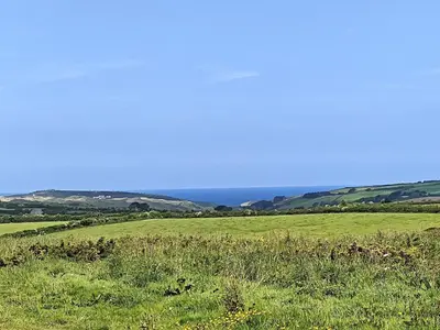 a green field with the ocean in the background at 2 Bed in Hendra Croft oc-h32360 in Cubert