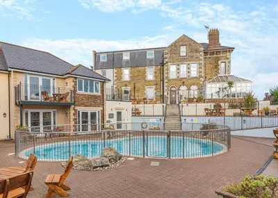 a large house with a swimming pool in front of it at Porth Veor in Saint Columb Minor
