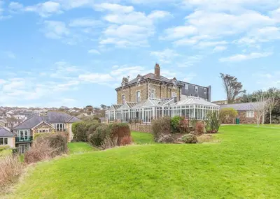 a large house with a lawn in front of it at Porth Veor in Saint Columb Minor