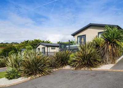 a house with plants in front of a driveway at Praa Sands Holiday Park in Praa Sands