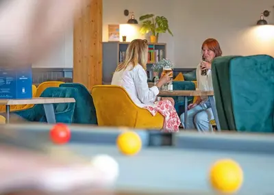 a man and woman sitting at a table with drinks at Praa Sands Holiday Park in Praa Sands