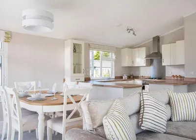 a living room and kitchen with a couch and a table at Praa Sands Holiday Park in Praa Sands