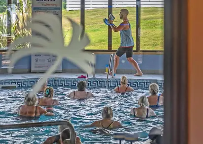 a group of people in a swimming pool with a man in the water at Praa Sands Holiday Park in Praa Sands