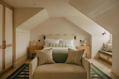 a bedroom with a large bed and a couch at Seaside Cottage in St Ives in St Ives