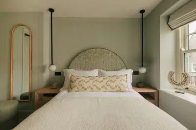 a bedroom with a large bed and two windows at Seaside Cottage in St Ives in St Ives