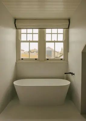 a white bath tub in a bathroom with a window at Seaside Cottage in St Ives in St Ives