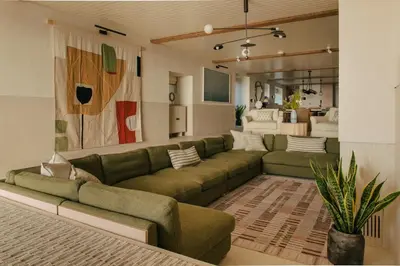 a living room with a large green couch in a room at Beachfront Apartment in St Ives in St Ives