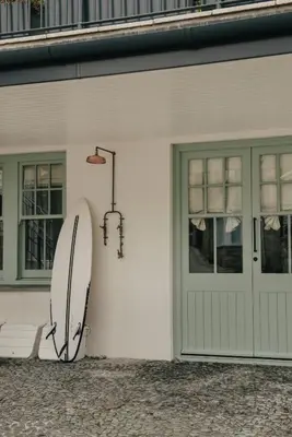 a surfboard leaning against the side of a house at Beachfront Apartment in St Ives in St Ives