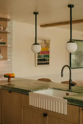 a kitchen with a sink and three lights at Beachfront Apartment in St Ives in St Ives
