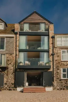 a brick house with a large glass window at Beachfront Apartment in St Ives in St Ives