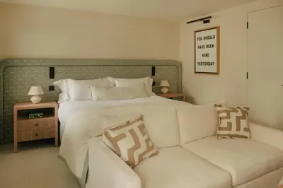 a bedroom with a large bed and a couch at Beachfront Apartment in St Ives in St Ives