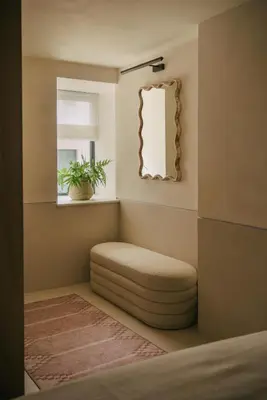 a room with a round ottoman and a mirror at Beachfront Apartment in St Ives in St Ives