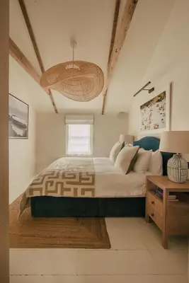 a bedroom with a large bed and a table at Cozy Cottage in St Ives in St Ives
