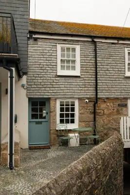 a house with a green door and a table outside at Cozy Cottage in St Ives in St Ives