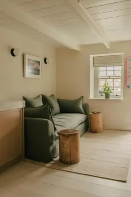 a living room with a green couch and a window at Cozy Cottage in St Ives in St Ives