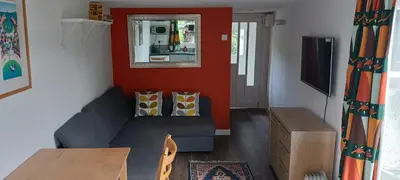 a living room with a couch and a television at Chy An Geddon in Penryn