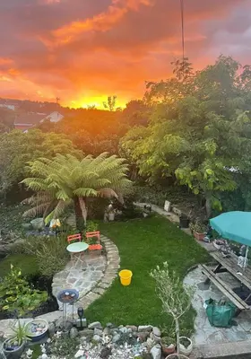 a view of a garden with a sunset in the background at Chy An Geddon in Penryn