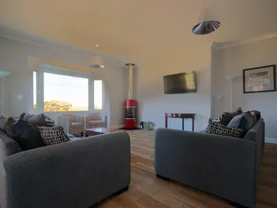 a living room with two couches and a window at Chynoweth in Crantock