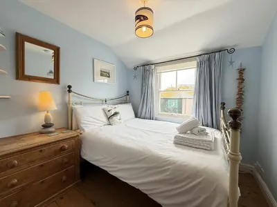a bedroom with a white bed and a window at Seabreeze in St Ives