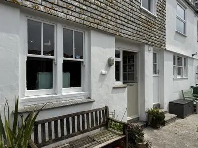 a white house with a bench in front of it at Seabreeze in St Ives