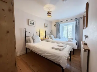 two twin beds in a room with a window at Seabreeze in St Ives