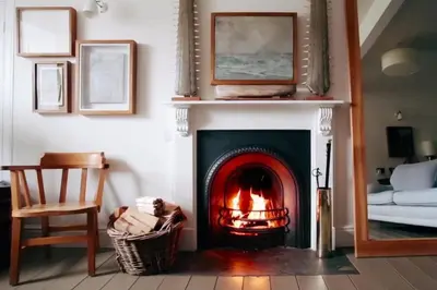 a living room with a fireplace and a chair at Antonia's Pearls in St Austell