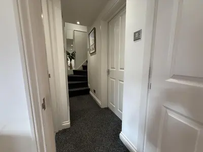 a hallway with white walls and a stair case at Pennys Place in St Ives
