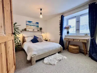 a bedroom with a bed and a desk and a sink at Boho Bali-style Beach House near Fistral in Newquay