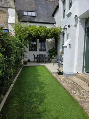 a yard with green grass next to a house at Headmasters House in Port Isaac