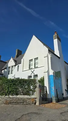 a white house with a painting on the side of it at Headmasters House in Port Isaac
