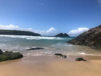 a sandy beach with rocks and the ocean at Entire Apartment in Pretty Coastal Village in Cubert