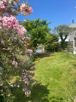 a garden with pink flowers in a yard at Entire Apartment in Pretty Coastal Village in Cubert