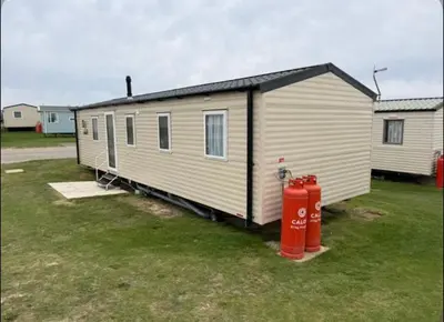 a tiny house with a red fire hydrant in a yard at Haven Holiday Park Perran Sands in Perranporth
