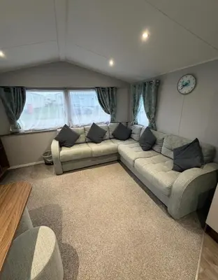 a living room with a large couch in a room at Haven Holiday Park Perran Sands in Perranporth